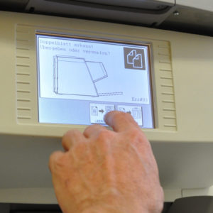 Hand zeigt auf Display eines Aktenscanners